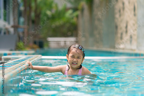 Cute girl having fun in summer in the pool summer vacation concept