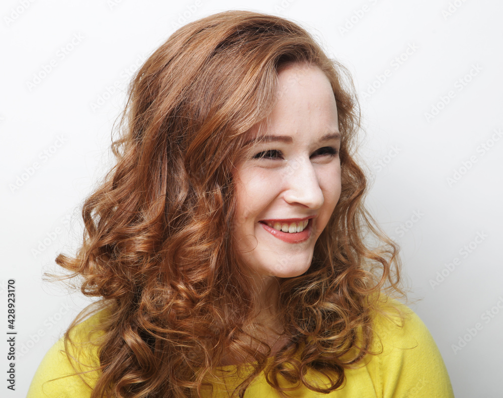 Fototapeta premium Emotion and people concept: pretty blond young woman smiling and laughing over white background