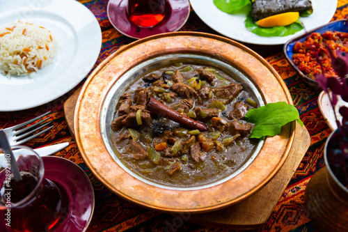 Mutancana, one of popular dishes of Ottoman Palace Cuisine from lamb with sweet dried fruits, honey and almonds photo