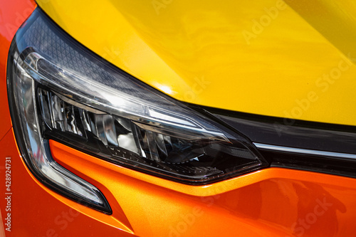 Orange car headlights. Exterior detail. Close up detail on one of the LED headlights modern car..