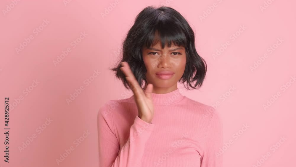 Unhappy dissatisfied dark skinned woman waves palm near nose smells unpleasant stench dressed in casual wear poses over pink background sees something disgusting. Avoiding bad smell, nasty feelings. Unhappy dissatisfied dark skinned woman waves palm near nose smells unpleasant stench dressed in casual wear poses over pink background sees something disgusting. Avoiding bad smell, nasty feelings.