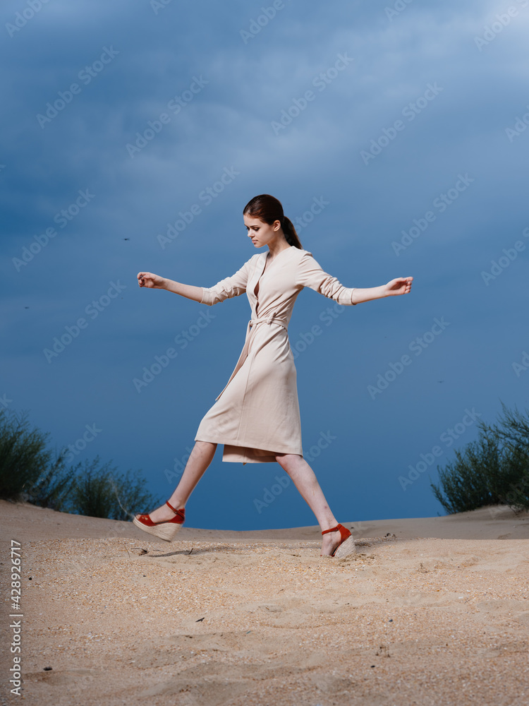 A woman walks along the beach in red sandals with a wide stride A woman walks along the beach in red sandals with a wide stride