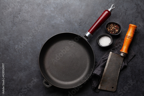 Frying pan, utensils and ingredients on kitchen table photo