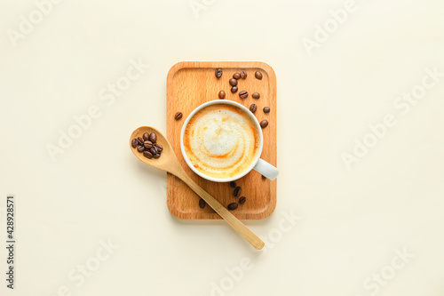 Cup of hot cappuccino coffee on light background