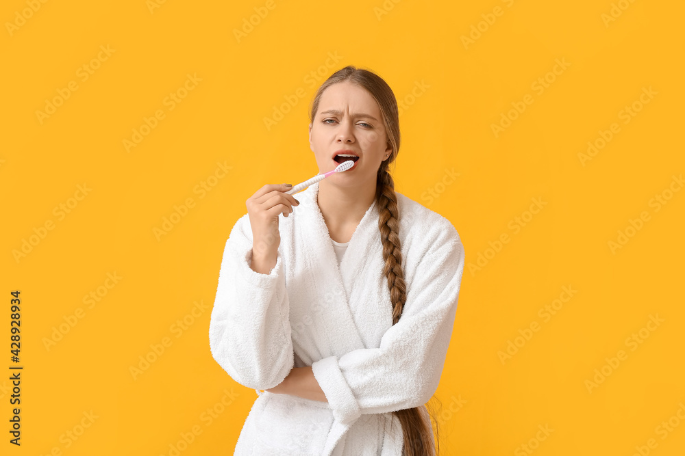 Displeased woman with tooth brush on color background Displeased woman with tooth brush on color background