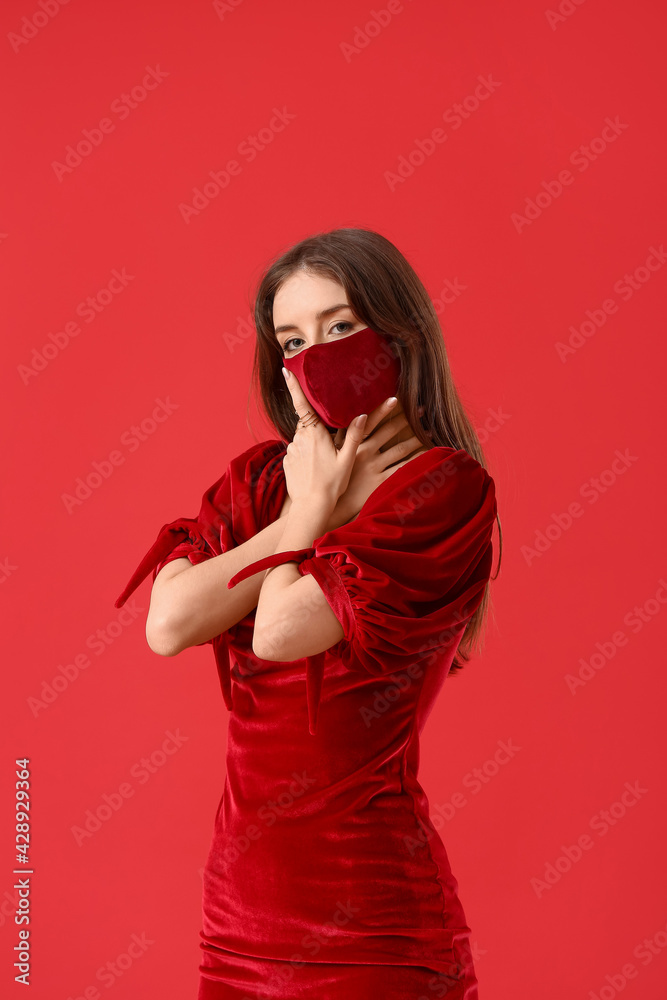 Fashionable young woman wearing mask on color background Fashionable young woman wearing mask on color background