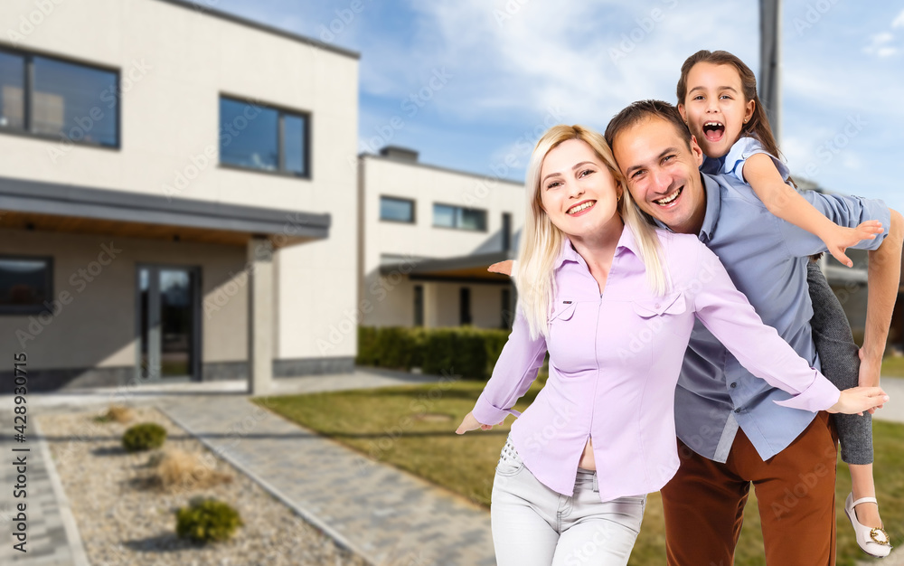 Happy family. family on the background of a new house. Modern new house is on the background.