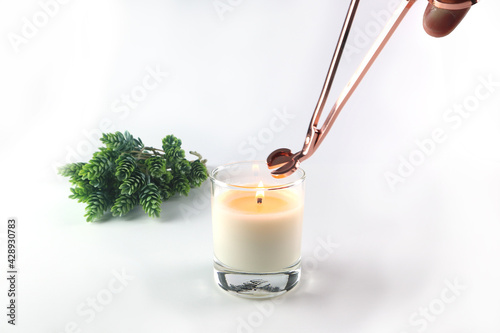 Foto nice scented candle on the white table is cut the wick by rose gold wick trimmer