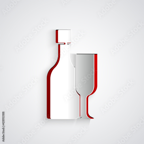 Paper cut Wine bottle with glass icon isolated on grey background. Paper art style. Vector
