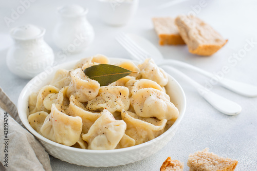 Handmade dumplings with meat on a white table, traditional Russian cuisine, horizontal