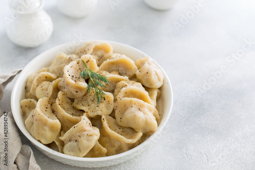 Handmade dumplings with meat on a white table, traditional Russian cuisine, horizontal, place for text