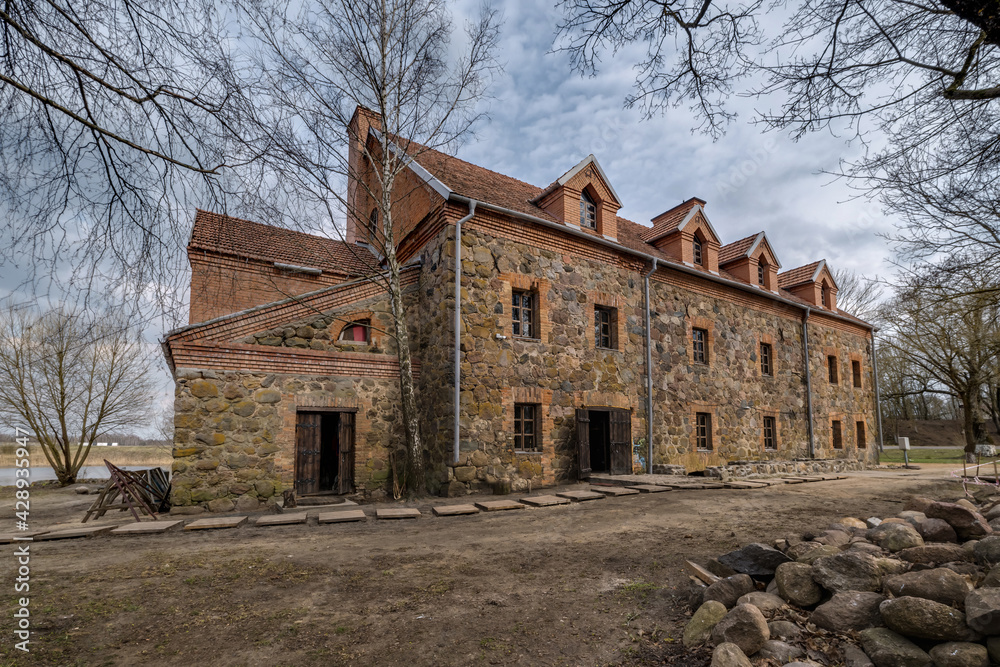 Fototapeta premium the building of the restored old stone mill in early spring