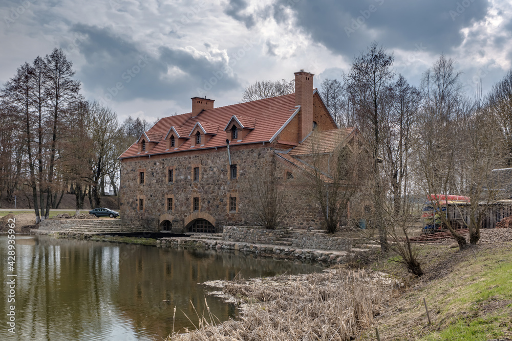 the building of the restored old stone mill in early spring near lake