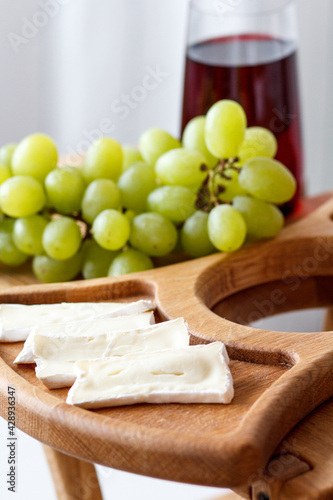 Serving wooden table for wine, glasses and snacks. Handmade segmented Portion wooden table. Grapes, cheese, wine and nuts.  