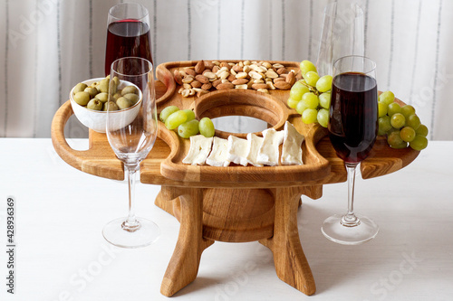 Serving wooden table for wine, glasses and snacks. Handmade segmented Portion wooden table. Grapes, cheese, wine and nuts.  