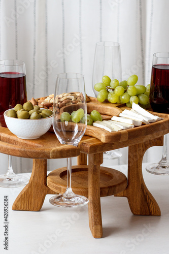 Serving wooden table for wine, glasses and snacks. Handmade segmented Portion wooden table. Grapes, cheese, wine and nuts.  