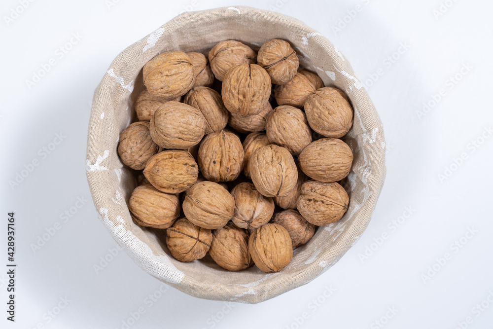 basket with whole walnuts on a white background, top view basket with whole walnuts on a white background, top view
