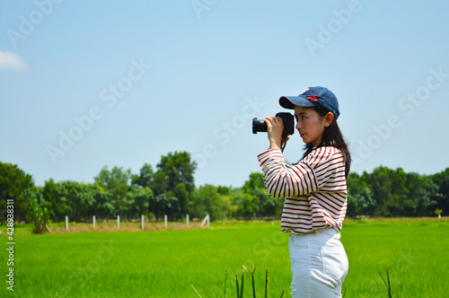 Women in striped shirts with white pants Using camera