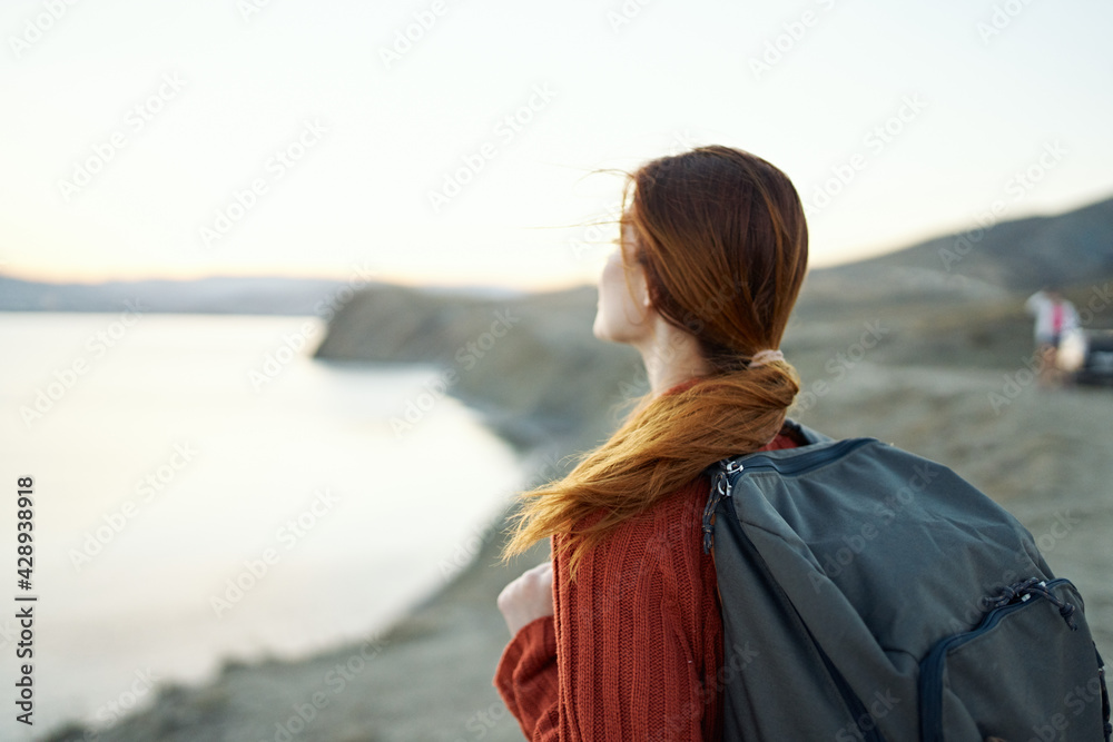 woman travels in the mountains in nature near the sea with a backpack on her back woman travels in the mountains in nature near the sea with a backpack on her back