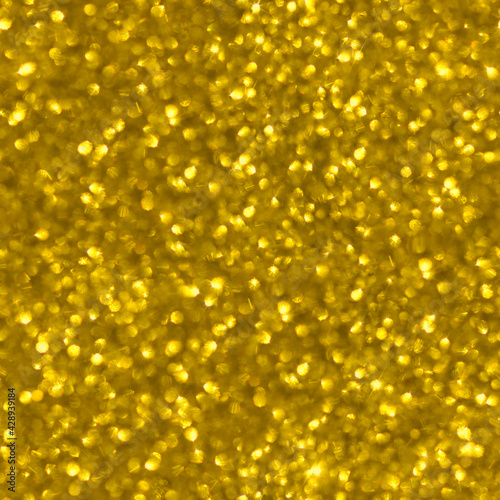 Seamless texture. Seamless shiny yellow background. Blurred background of yellow sparkles.