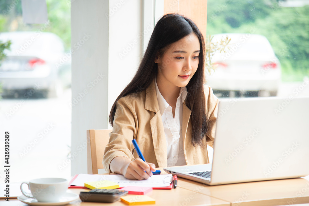 Happy businesswoman using laptop in the office.woman working on a laptop in cafe. Happy businesswoman using laptop in the office.woman working on a laptop in cafe.