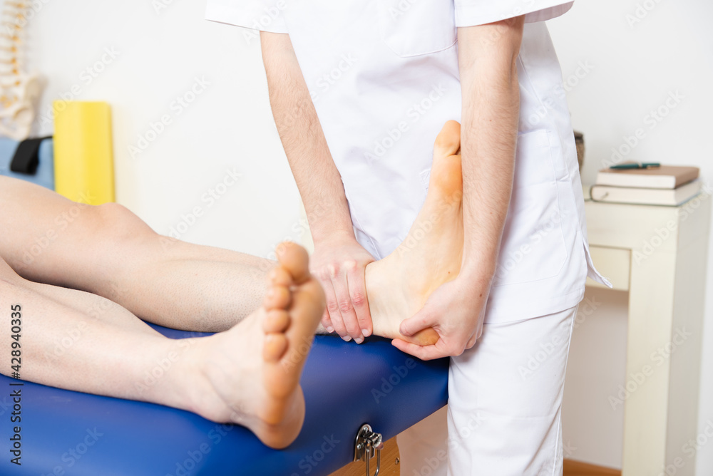 Fototapeta premium Closeup view of a physiotherapist treating the foot and ankle mobility of a sportive patient.