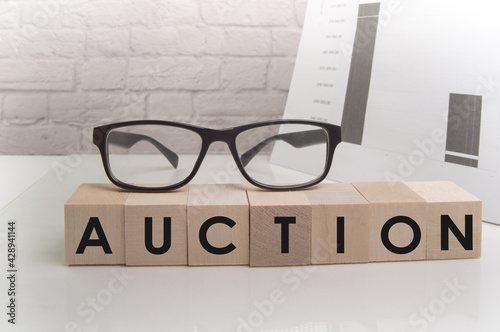 Action word on wooden cubes on white office background with glasses, documents and brick wall