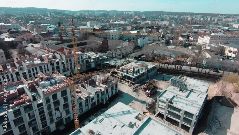 Flying drone above residential area with new real estate apartment building being built on construction site. Aerial landscape. New development. Flying drone above residential area with new real estate apartment building being built on construction site. Aerial landscape. New development.