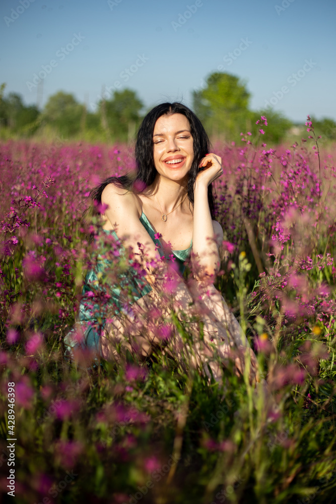 Girl in a turquoise dress in a blooming field Girl in a turquoise dress in a blooming field