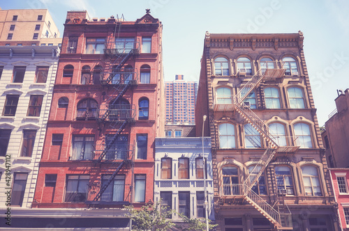 Canvas Print Old buildings with fire escapes in New York City, color toning applied, USA