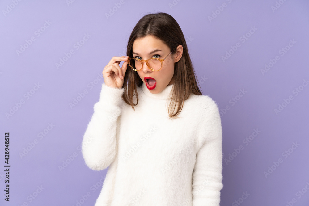 Teenager girl isolated on purple background with glasses and surprised Teenager girl isolated on purple background with glasses and surprised