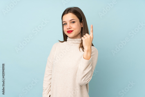 Teenager girl isolated on blue background pointing with the index finger a great idea