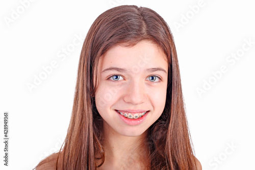 Beautiful young teen girl with brackets on teeth in white photo