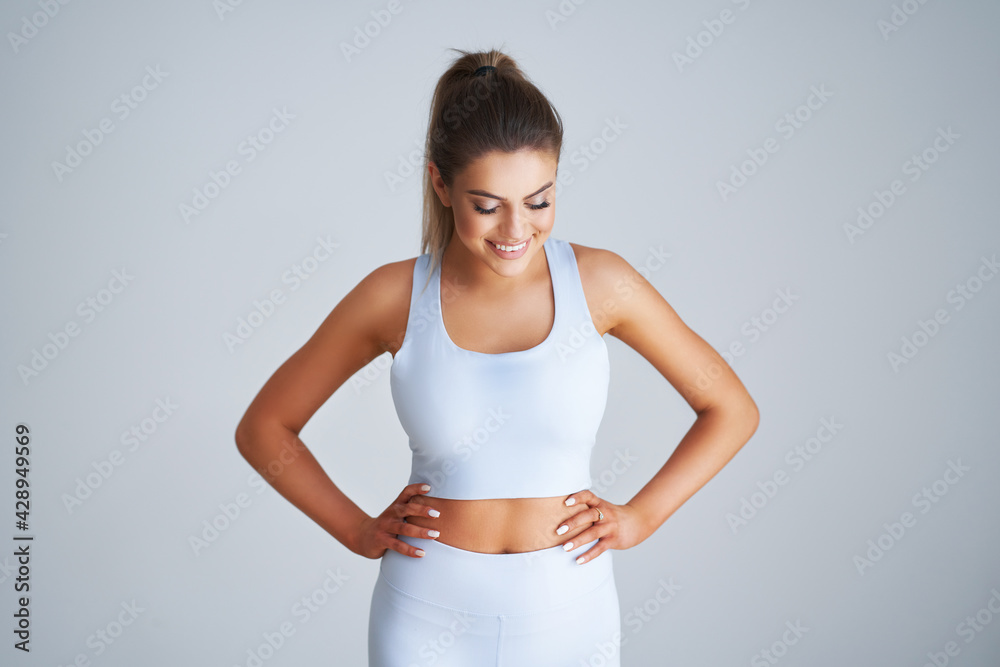 Adult beautiful woman working out over light background Adult beautiful woman working out over light background