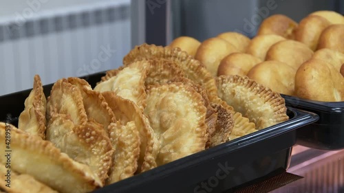 chebureki and peremech in bakery, deep-fried turnover with filling, russian and oriental cuisine photo