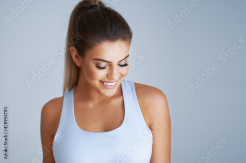 Adult beautiful woman working out over light background