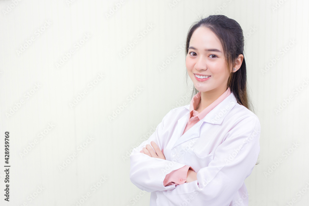 Asian woman doctor who she has a black long hair, wear a stethoscope and a white lab coat as a uniform while arm cross at office room in hospital in health care and new normal protection concept. Asian woman doctor who she has a black long hair, wear a stethoscope and a white lab coat as a uniform while arm cross at office room in hospital in health care and new normal protection concept.