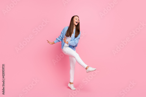 Full size photo of funky carefree young woman dance free time wear white shoes isolated on pink color background