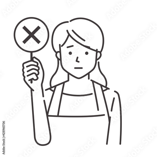 バツを出すエプロン姿の若い女性