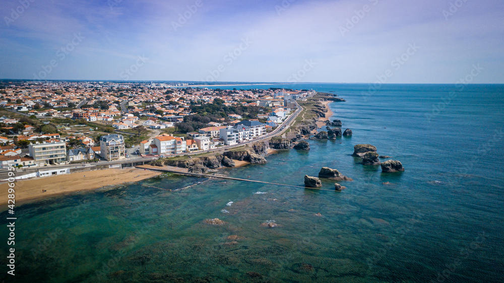 Aerial view from a magnificent coastline between cliffs, beaches, clear water and city. That place is called 