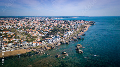 Aerial view from a magnificent coastline between cliffs, beaches, clear water and city. That place is called 