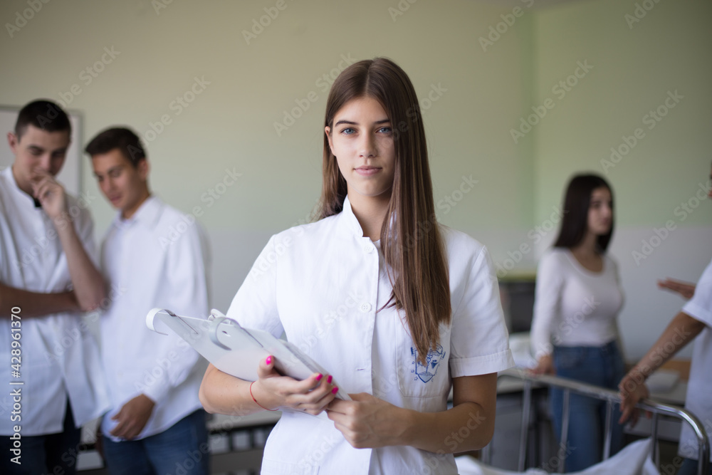 Time for checking a patient. Medical students in patient room. Focus is on foreground. Time for checking a patient. Medical students in patient room. Focus is on foreground.