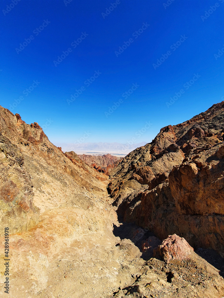 hiking trail in Eilat mountains. Red rock formations and boulders. Panoramic view over the trail on surrounding red mountains. Eilat, Israel Israel, Eilat Mountains: Red Canyon