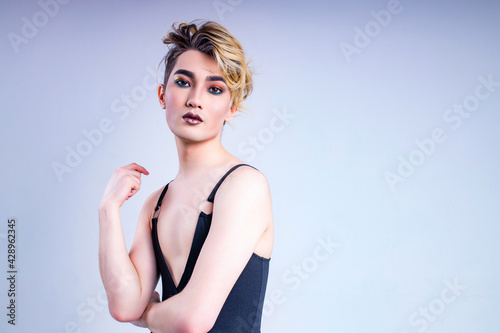 asian man with luxurious blonde hair and gorgeous make-up in white wall studio background passion look at camera photo