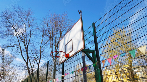 backyard playground - basketball hoop on a backboard against a backdrop of residential buildings and blue sky