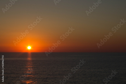 evocative image of sunrise over the sea with the sun rising on the horizon © massimo