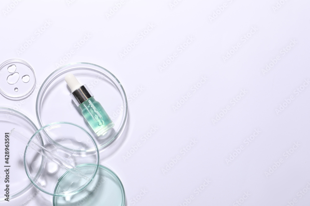 Organic cosmetic product and laboratory glassware on white background, top view. Space for text Organic cosmetic product and laboratory glassware on white background, top view. Space for text
