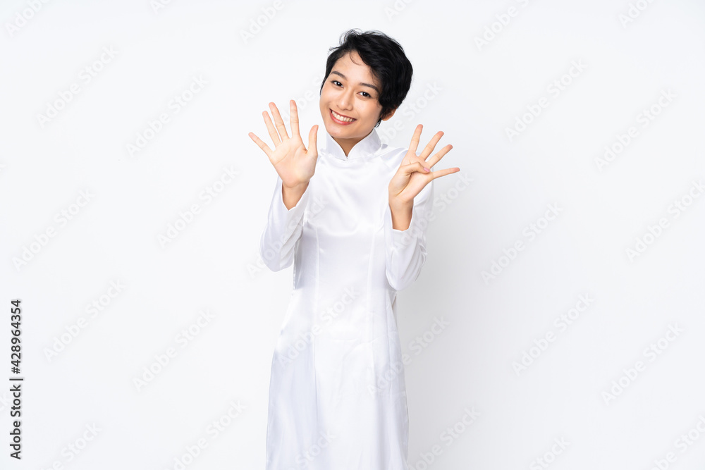 Young Vietnamese woman with short hair wearing a traditional dress over isolated white background counting nine with fingers Young Vietnamese woman with short hair wearing a traditional dress over isolated white background counting nine with fingers
