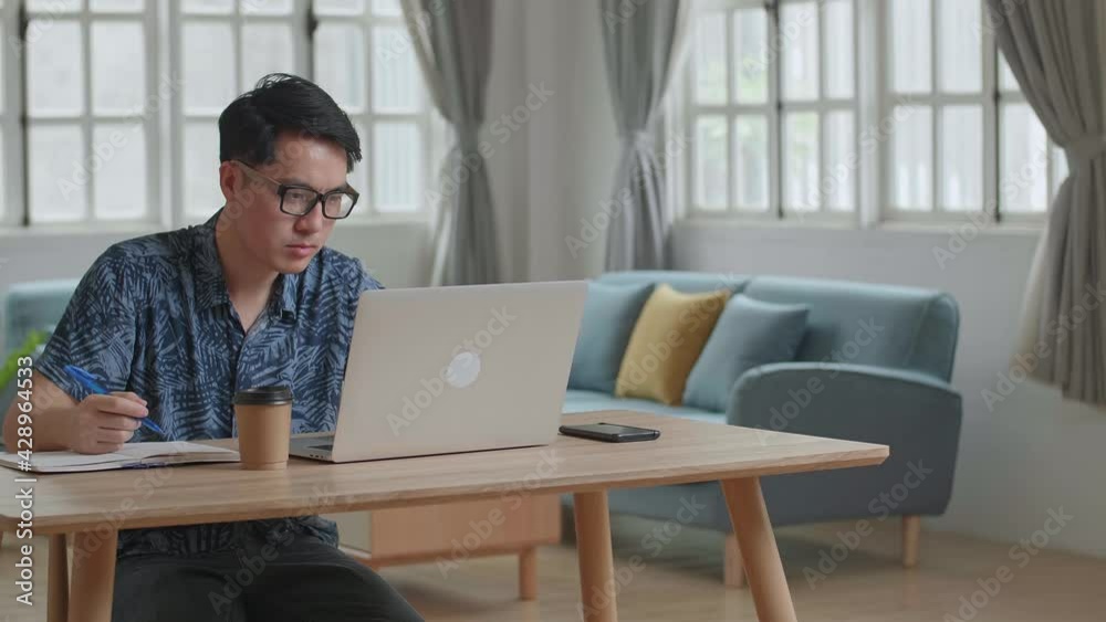 Upset Man Working On Laptop Computer At Home