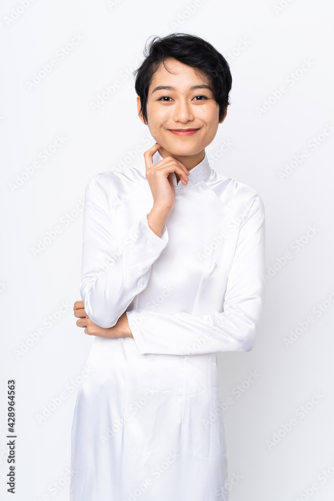 Young Vietnamese woman with short hair wearing a traditional dress over isolated white background Young Vietnamese woman with short hair wearing a traditional dress over isolated white background